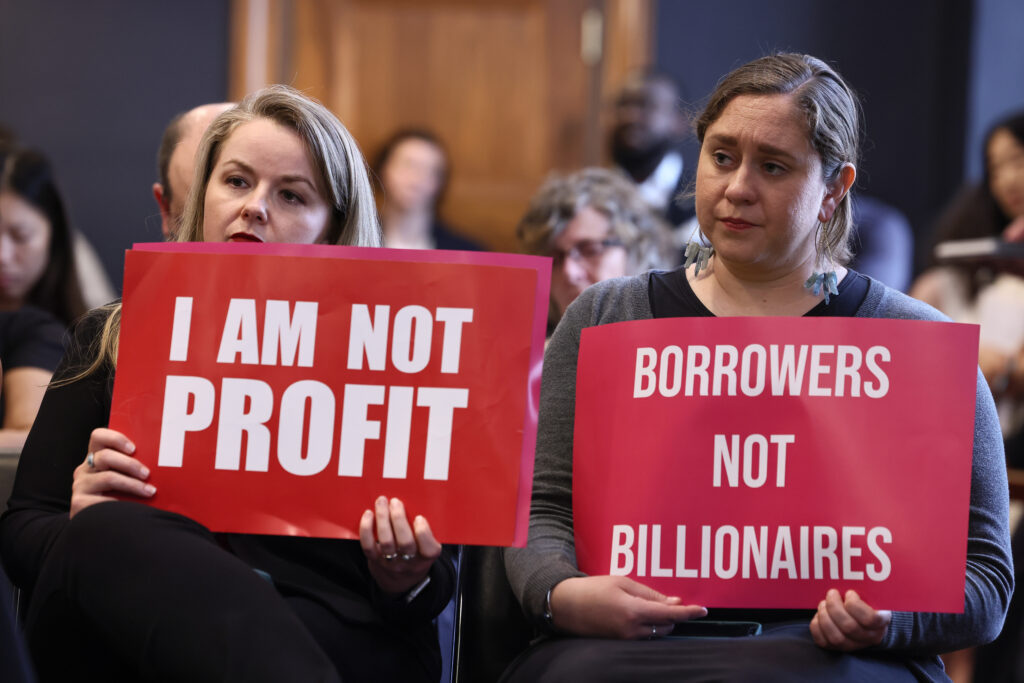 WASHINGTON, DC - MAY 14: Audience members hold up signs during a special forum on the rising cost of education at the Dirksen Senate Office Building on May 14, 2025 in Washington, DC. (Photo by Jemal Countess/Getty Images for Student Borrower Protection Center)