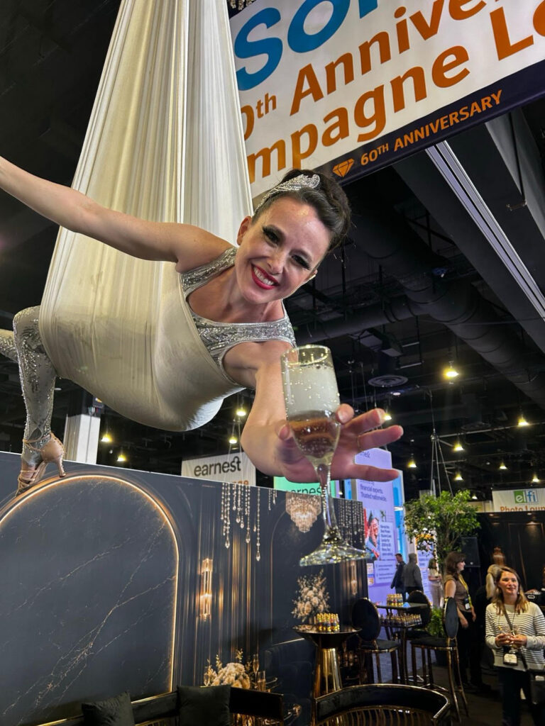 An aerialist is plying financial aid officials with champagne paid for by private student lenders at the National Association of Student Financial Aid Administrators’ 60th Anniversary Gala in 2026. Source: The American Prospect article "Student Loan Borrowers Beware" by James Baratta from July 23, 2026.